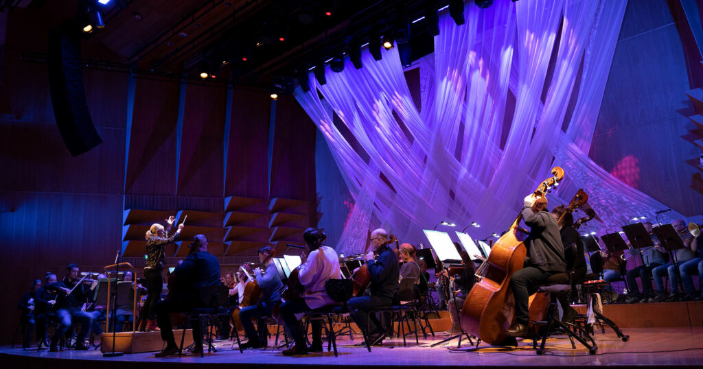 Orkesteri ja kapellimestari lavalla.