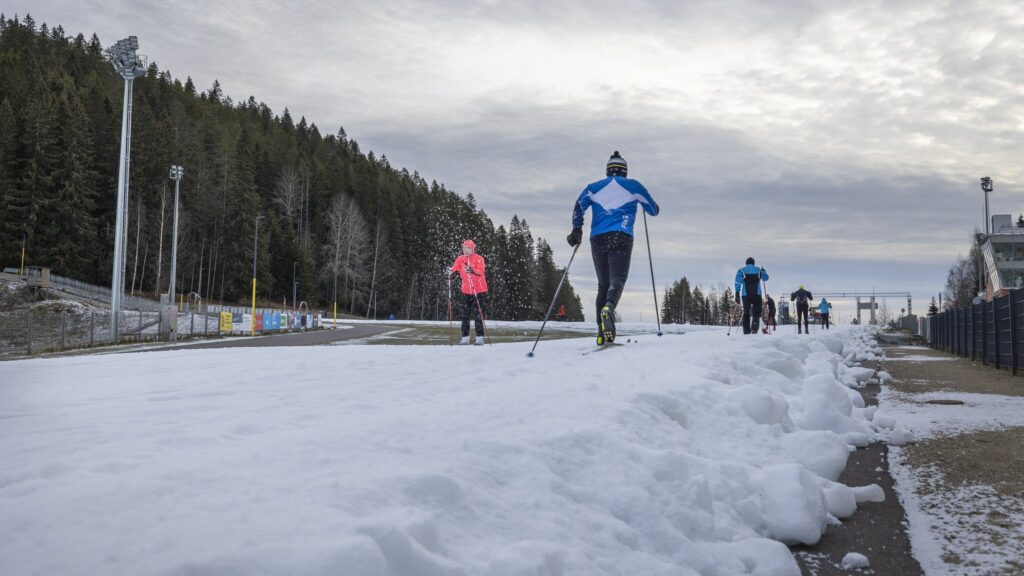 Hiihtäjiä hiihtämässä Puijon hiihtostadionilla ensilumenladulla