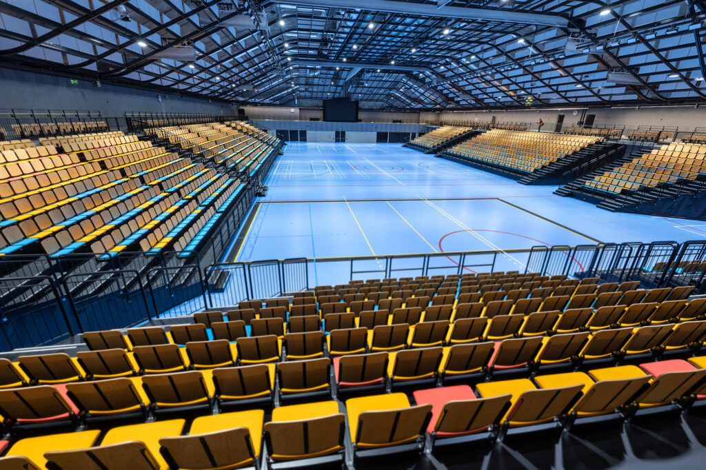 Kallion sisään louhittu, suuri liikuntakenttä, jonka reunoilla on värikkäät katsomot.