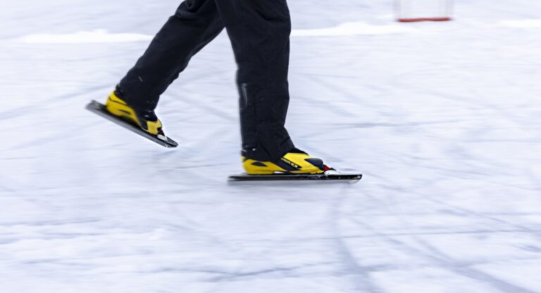 Jäällä luistelevan henkilön jalat.