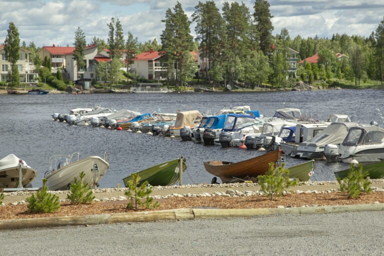 Pirttilahden venelaiturissa useita veneitä, taustalla omakotitaloja.