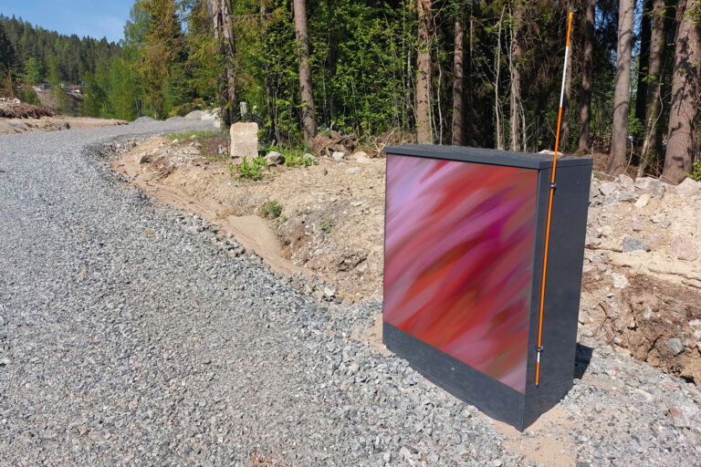 Sähkökaappi, johon on maalattu punainen taideteos.