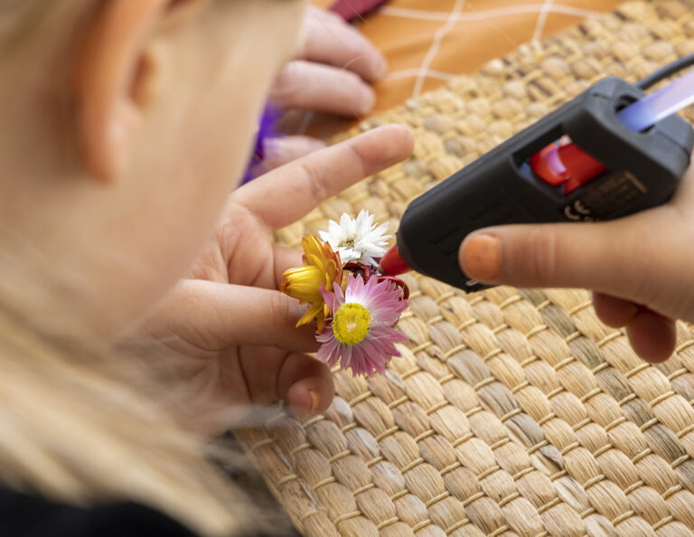 Lapsi askartelemassa kukka-teosta