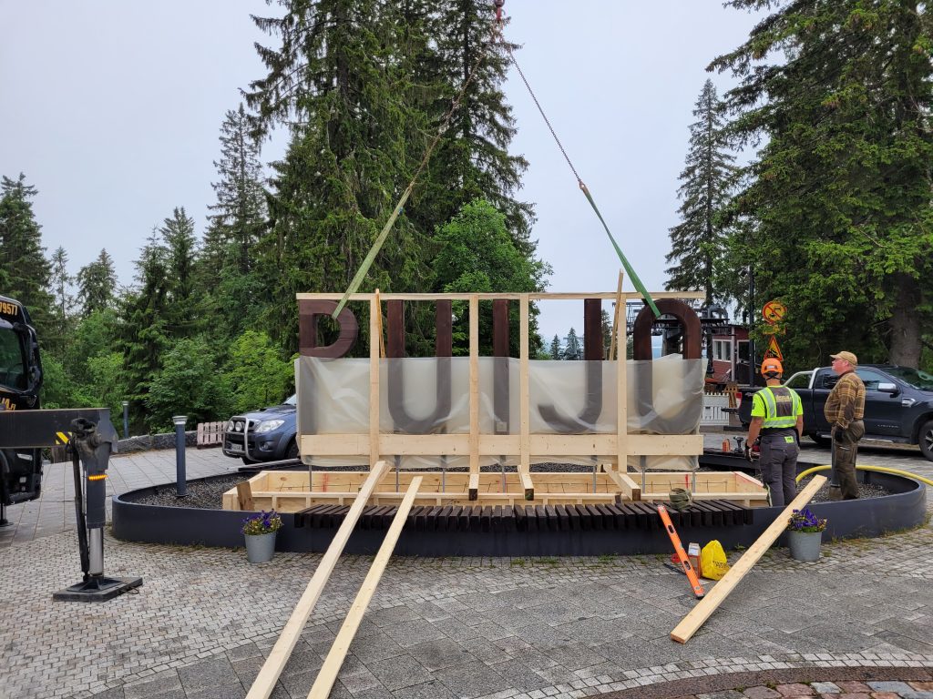 Kuvassa PUIJO-kirjainkylttiä asennetaan Puijon laelle.